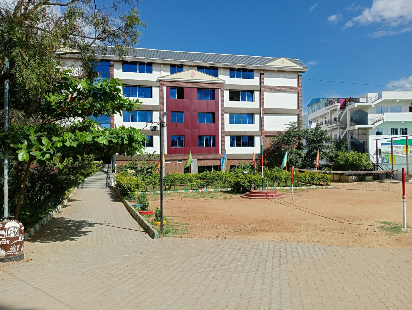 Modernes Schulgebäude mit roten Abschnitten und blauen Fenstern.
